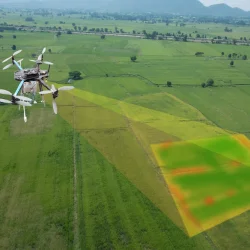 a drone flying over a green field