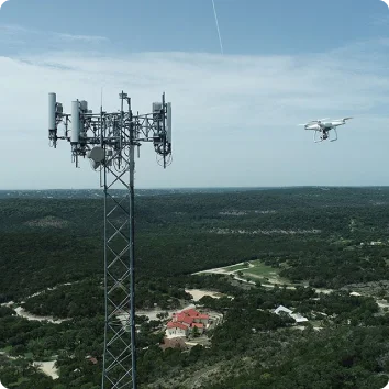 a drone flying over a large metal tower